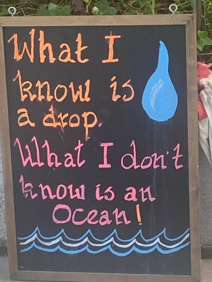 A colorful chalkboard reading: What I know is a drop. What I don’t know is an ocean.